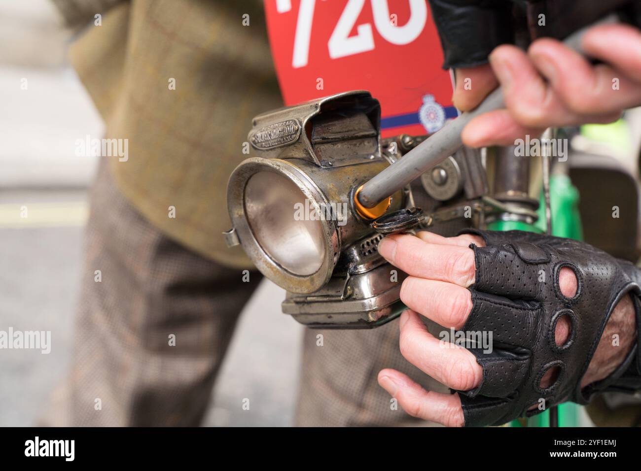 Central London, UK. 2nd November 2024. Lighting a bicycle lamp with a lighter. The wonderful pioneering vehicles on display today at the inaugural of St James’s Motoring Spectacle, showcasing many the Veteran Car Run stars, everything from the earliest vintage motor cars and motorcycles to the latest hypercars in central London England UK  Credit: Xiu Bao/Alamy Live News Stock Photo