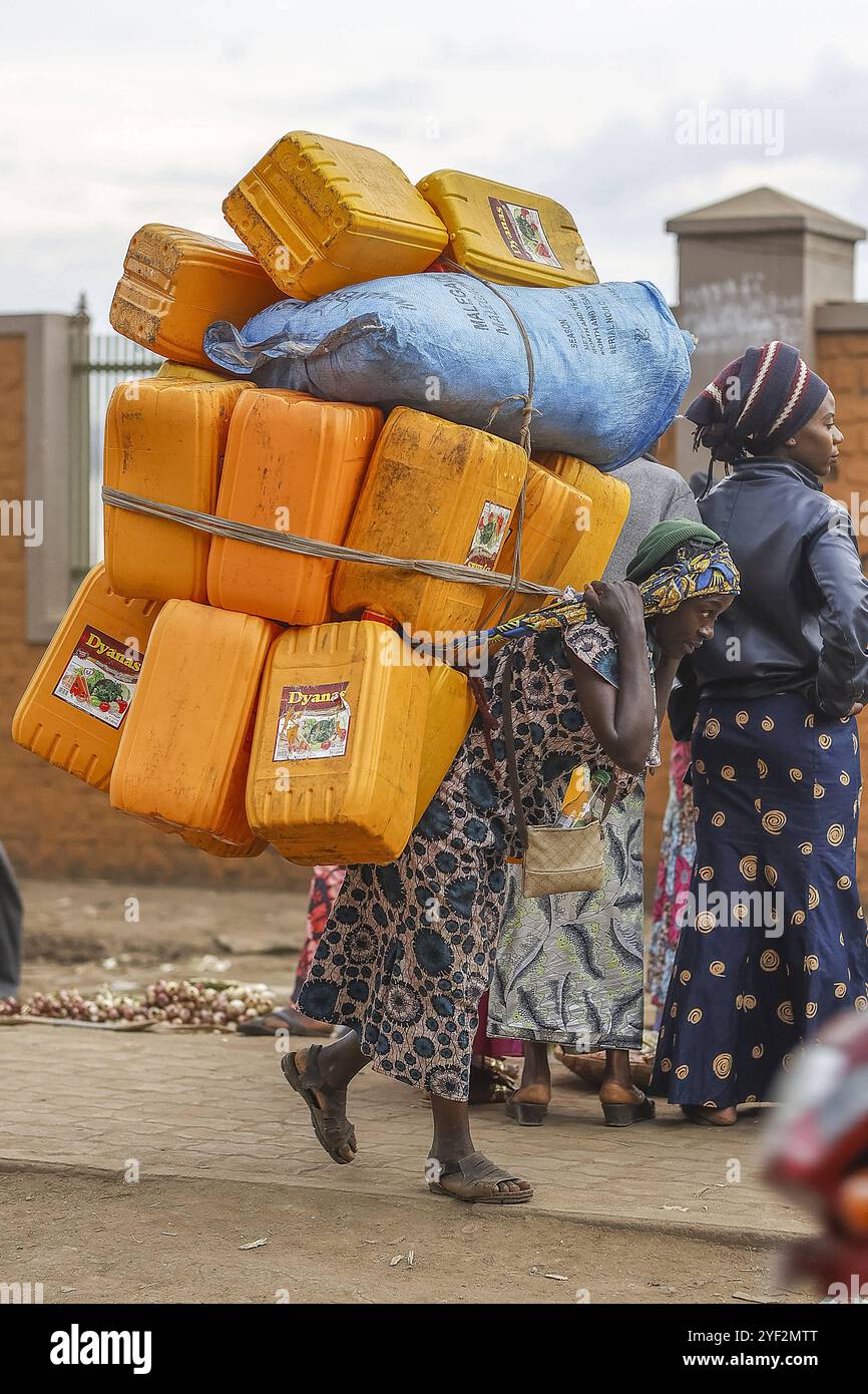 Woman carrying a load of jerricans on her back in Bukavu, DRC. Person ...