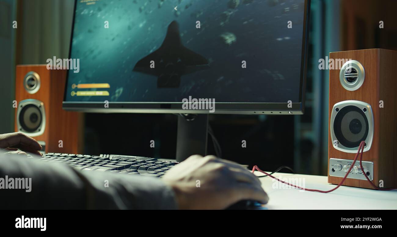 Gamer using keyboard and wired mouse to play videogames on desktop PC ...