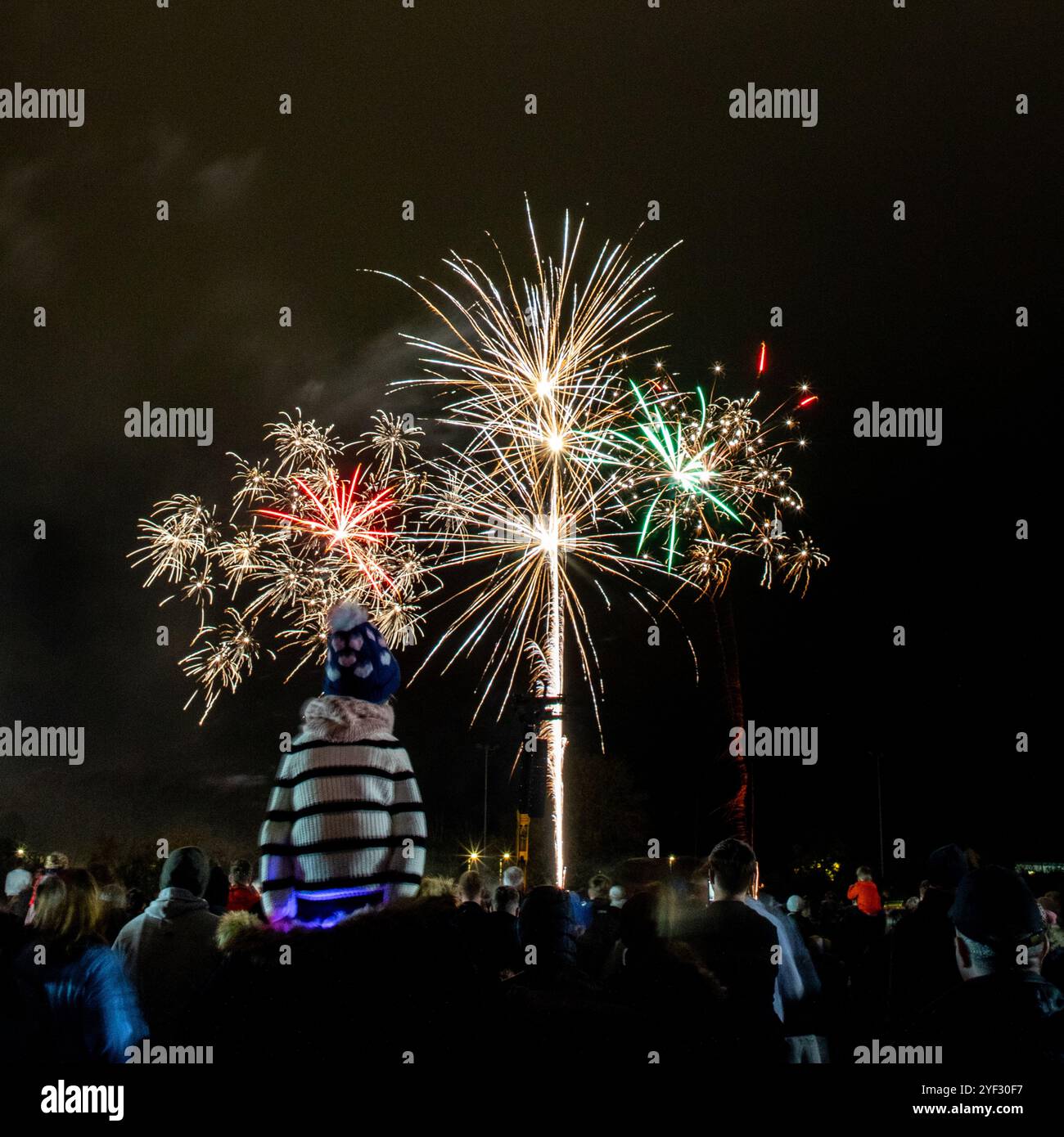 Crowds watching the Bicester Round Table 2024 annual fireworks display in Pingle Field, Bicester, Oxfordshire. Stock Photo