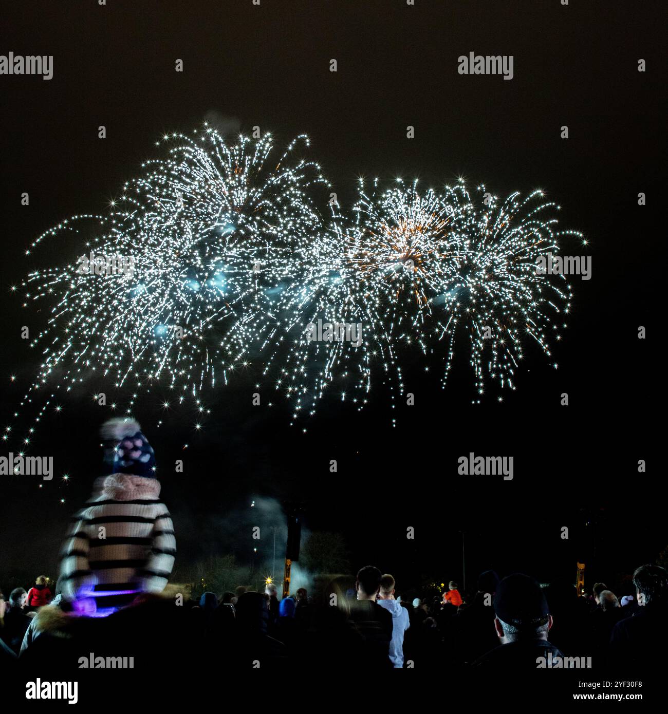 Crowds watching the Bicester Round Table 2024 annual fireworks display in Pingle Field, Bicester, Oxfordshire. Stock Photo