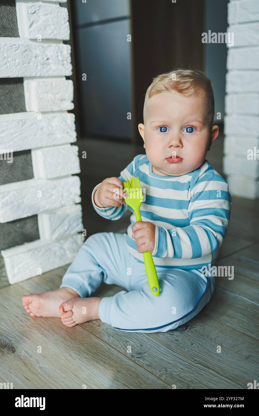 Happy smiling child. A cute little newborn baby boy with a smiling face is crawling on the floor. Motherhood baby care concept happy baby Stock Photo