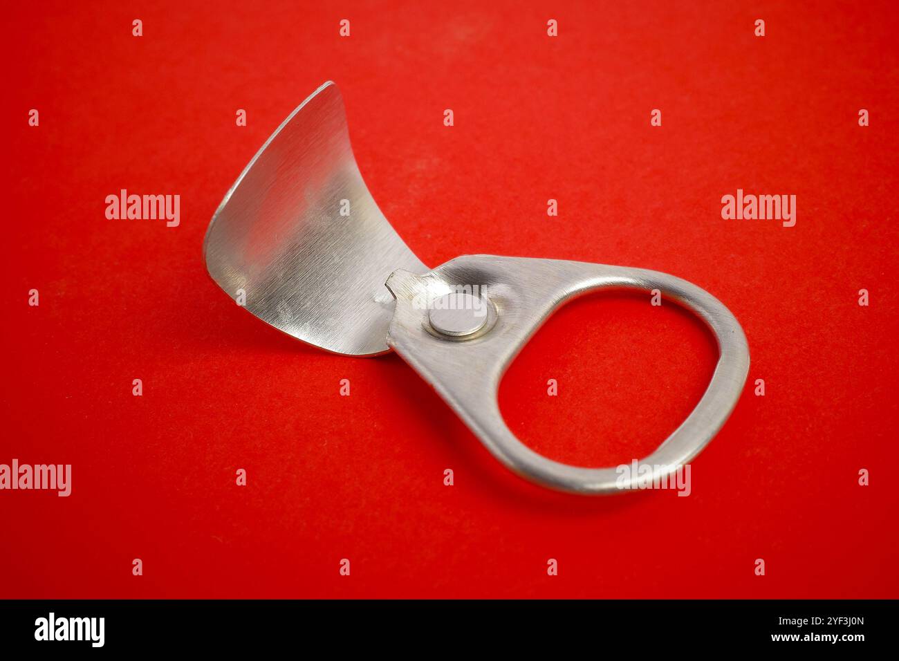Silver Pull Tab on a Red Background Stock Photo