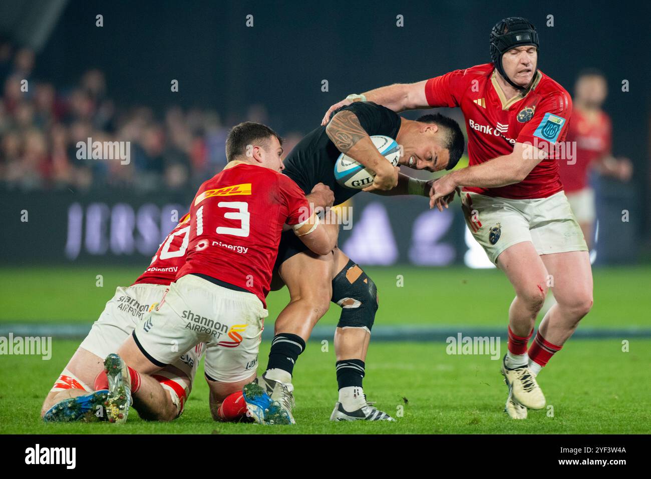 Quinn Tupaea of All Blacks tackled by Rory Scannell of Munster and Tom ...