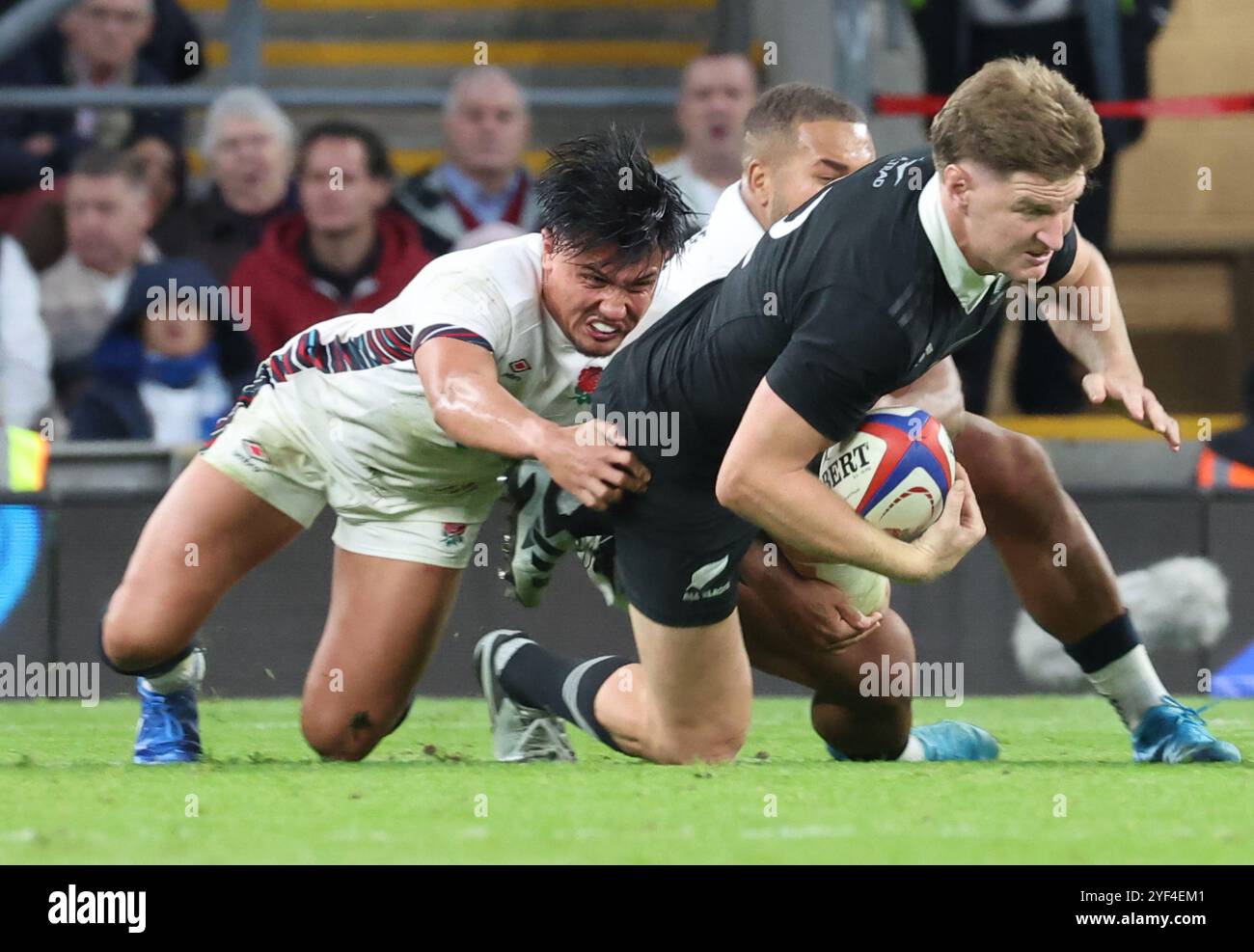 Jordie Barrett of New Zealand gets tackled by England's Marcus Smith