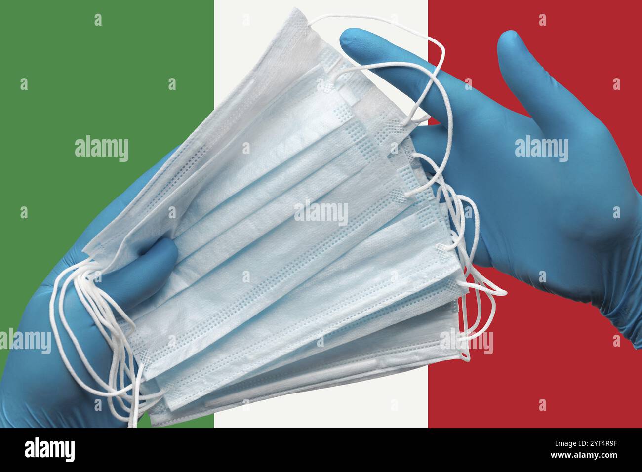 Doctor holding face masks in hands medical blue gloves on background national flag of Italy. Concept coronavirus quarantine, pandemic outbreak, grippe Stock Photo