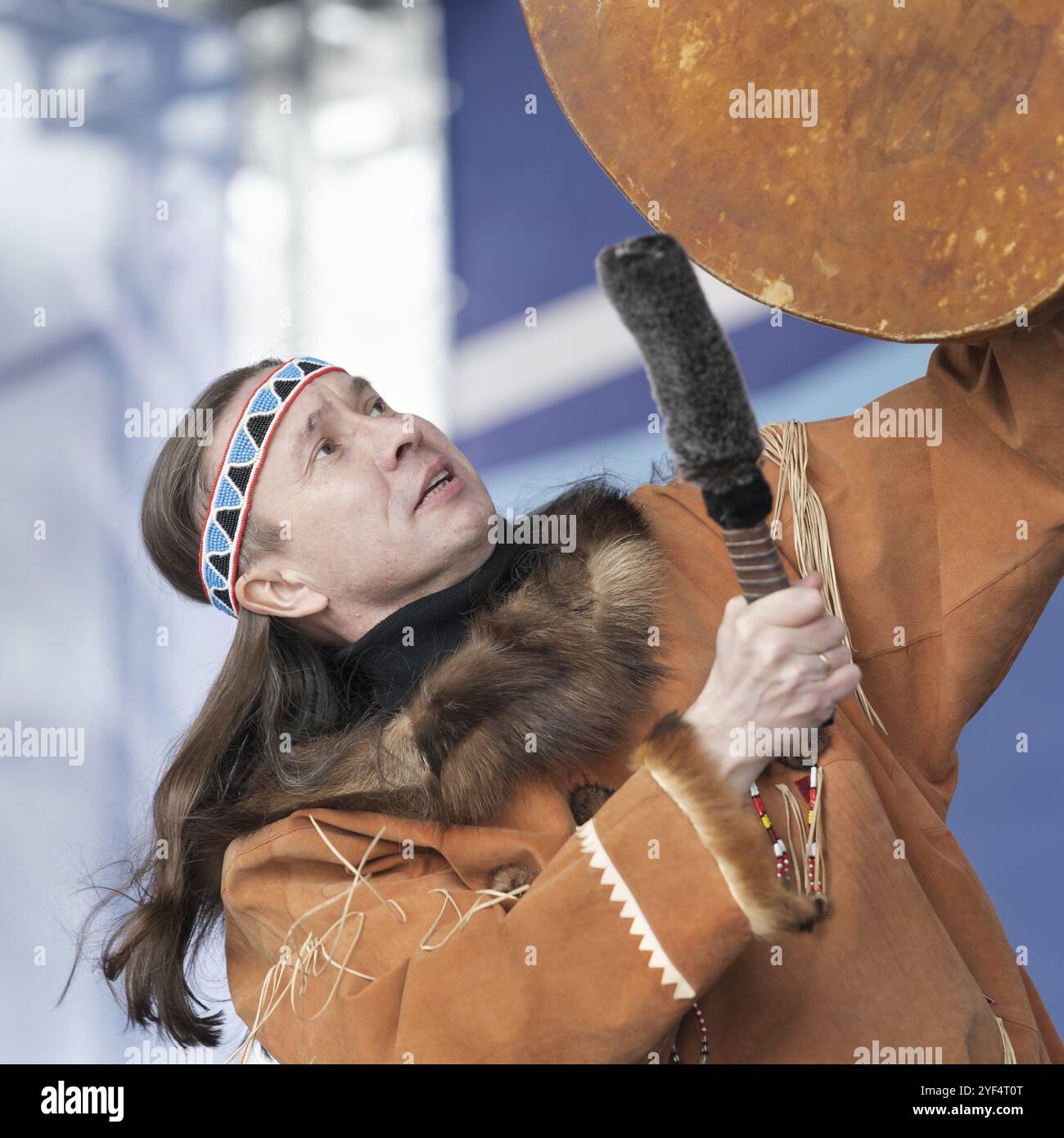 Male dancer in traditional clothes indigenous people emotional dancing with tambourine. Concert Koryak Dance Ensemble Mengo during Russian Alpine Skii Stock Photo