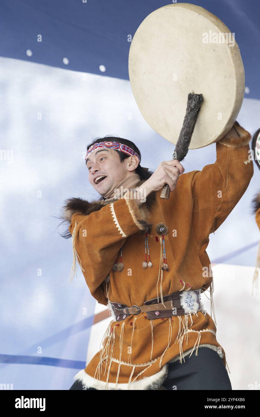 Aboriginal dancer in national clothes of native people emotional dancing with tambourine. Concert Koryak Dance Ensemble Mengo during Russian Alpine Sk Stock Photo