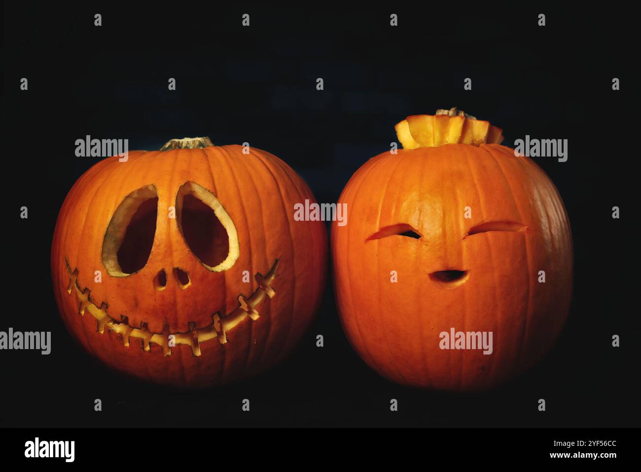 Two funny Halloween Pumpkins on dark background. Stock Photo