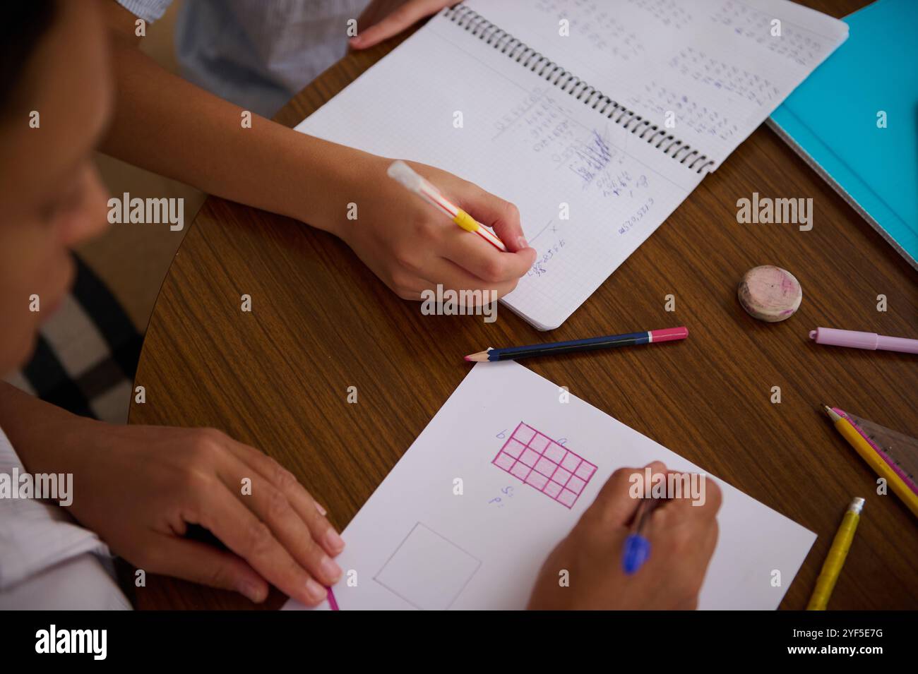 Top view of students working together on math homework, using pencils ...