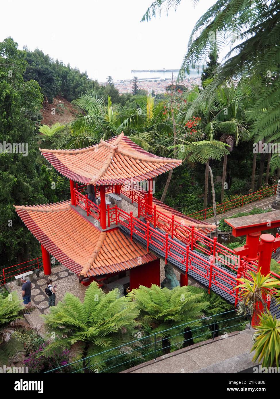 A beautiful traditional red pagoda situated amidst lush tropical ...