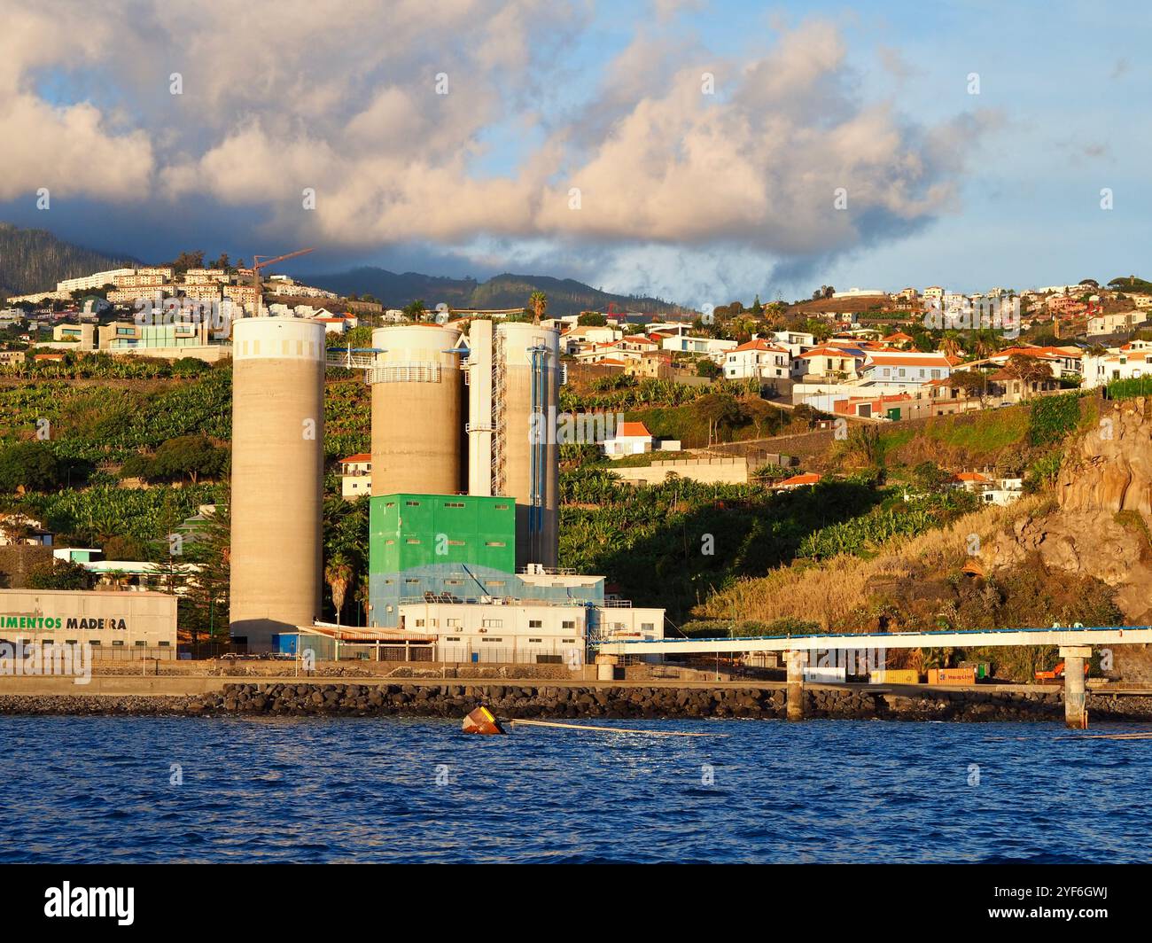 A prominent cement factory is set amidst a lush green landscape ...
