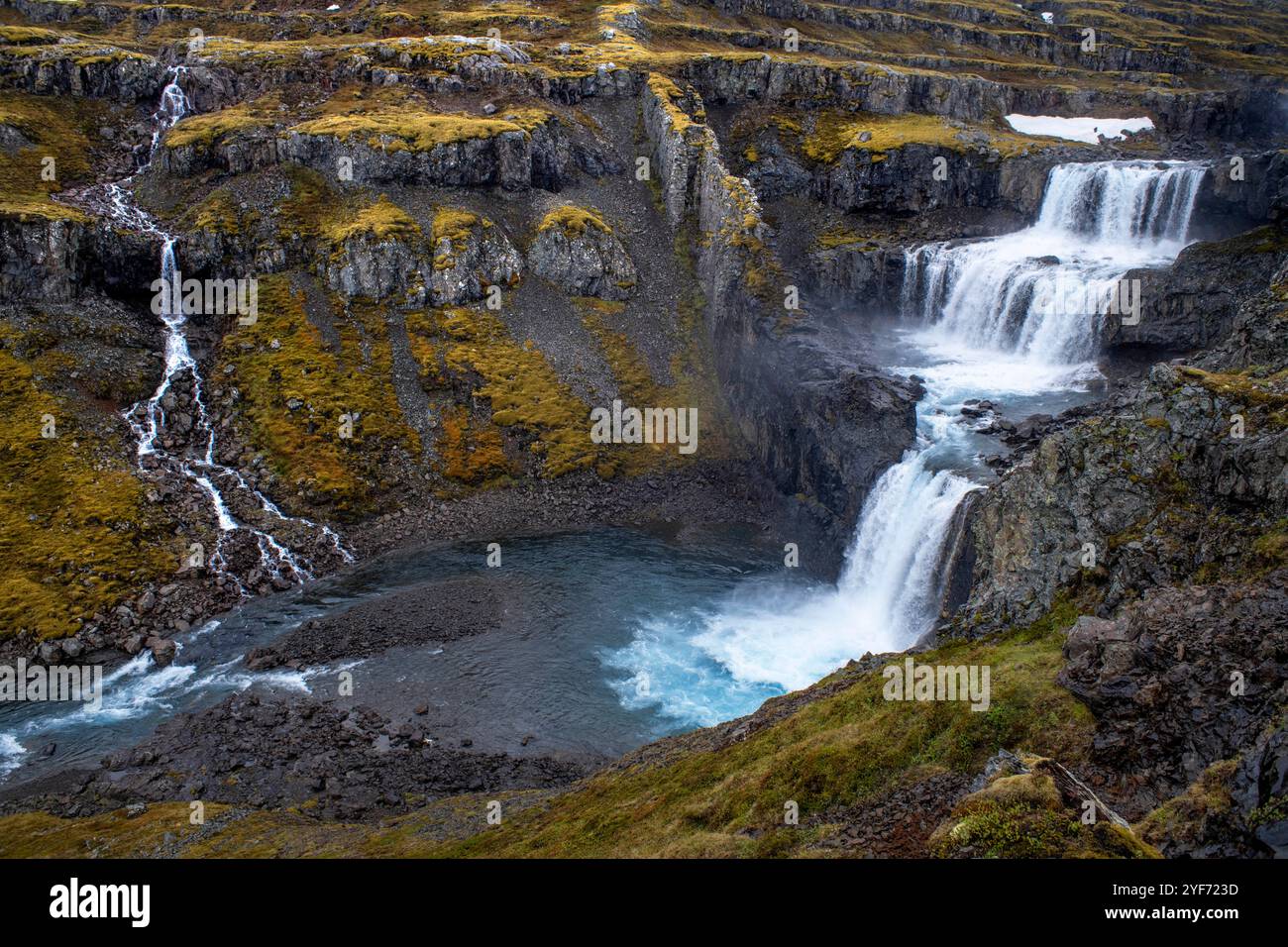 Flourishing in the valley Fossárdalur, Múlafoss waterfall is the last one among the series of waterfalls before the Fossá River embraces the Atlantic Stock Photo