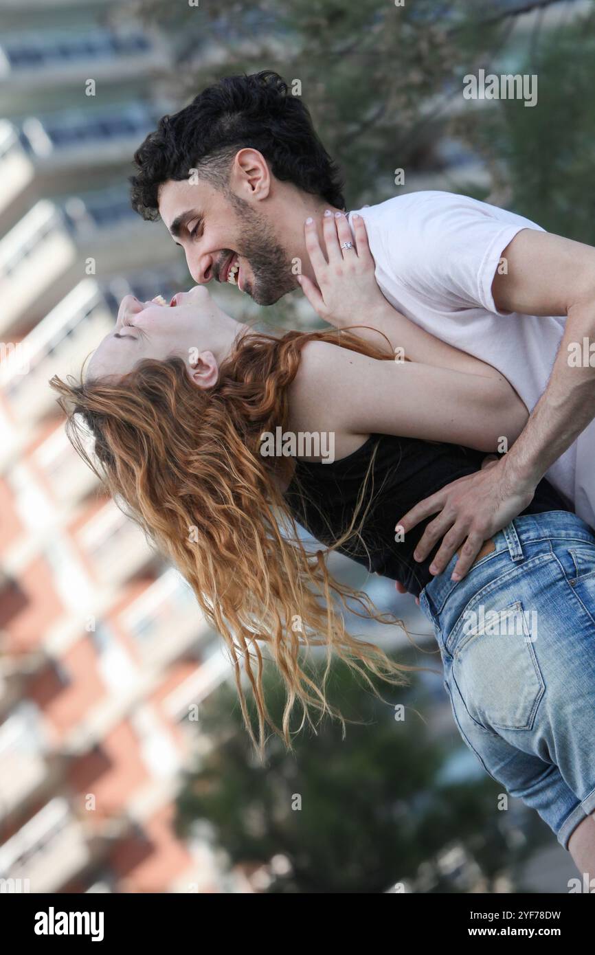 cheerful loving young couple having fun at the city park hugging and ...