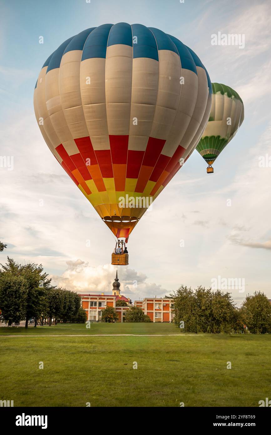 Colorful hot air balloon flying over blue sky with white clouds Stock ...