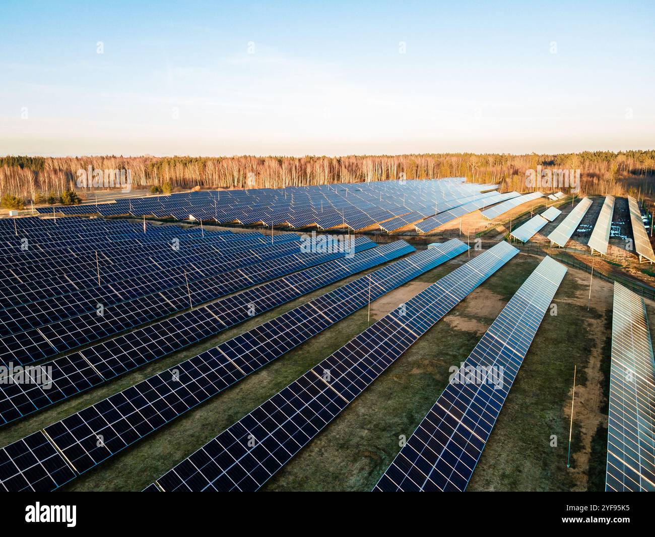 Aerial view of a large solar farm at sunset with rows of photovoltaic ...