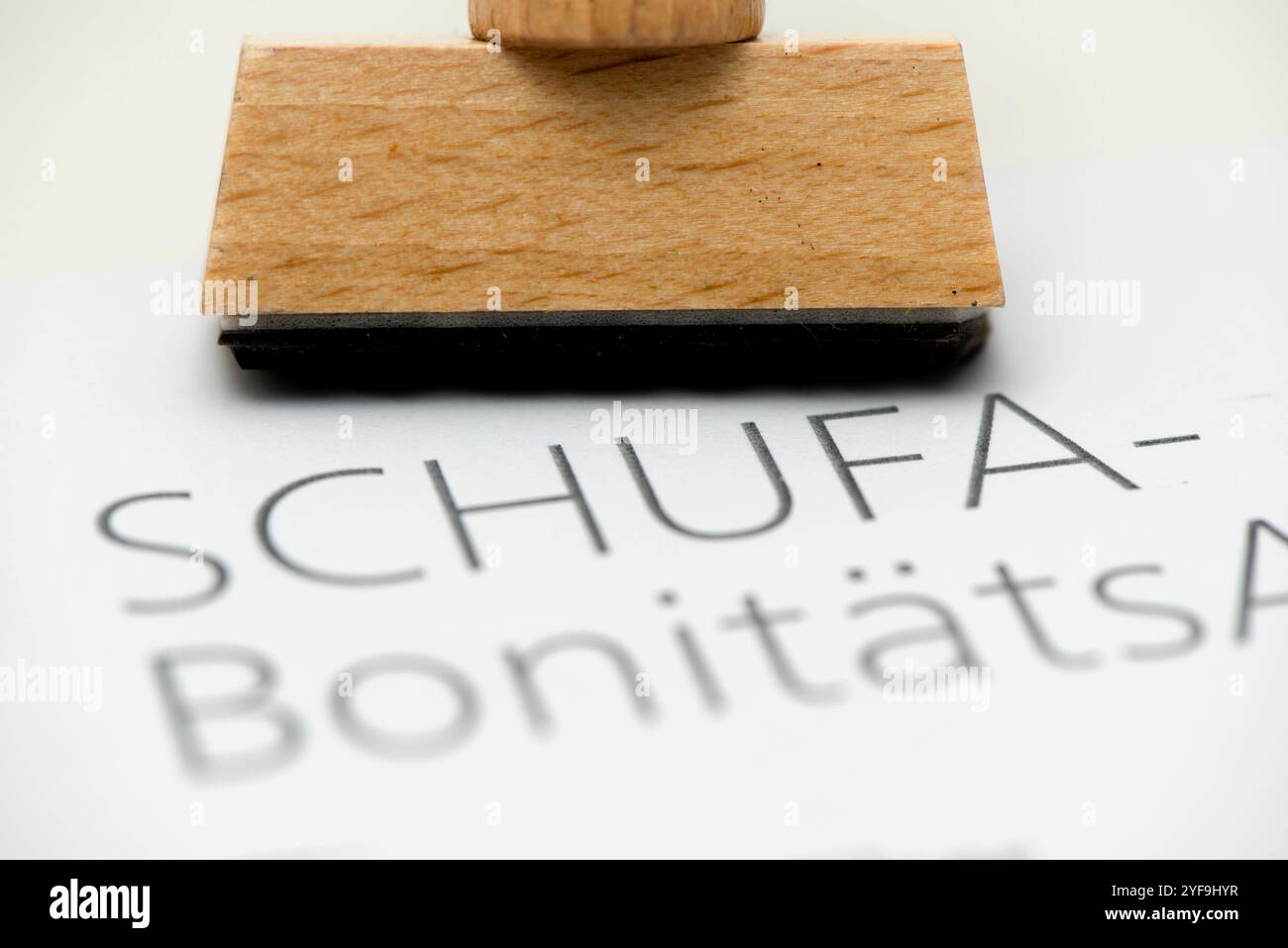 SCHUFA Bonitätsauskunft Ein Holzstempel mit Freiraum für individuellen Text steht auf einem Formular der SCHUFA Bonitätsauskunft *** SCHUFA credit rep Stock Photo