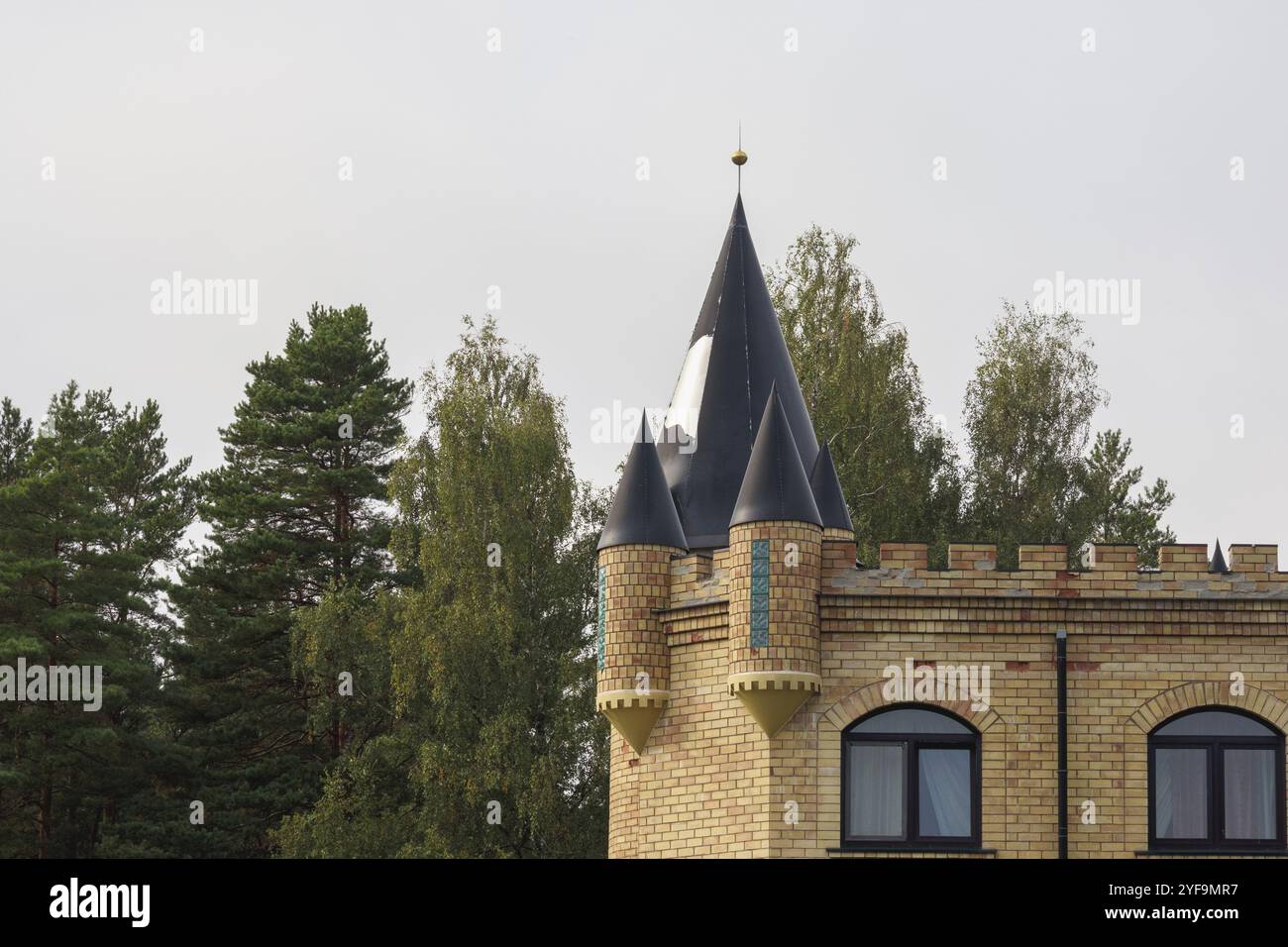 a yellow brick building with a pointed tower Stock Photo - Alamy