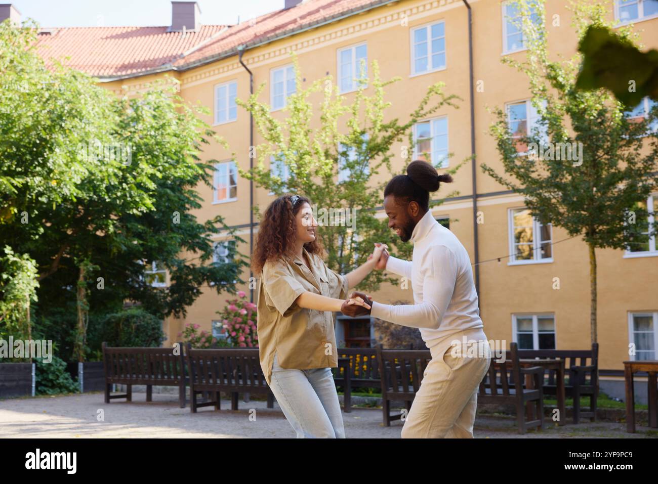 Multiracial couple practicing salsa dance in building back yard Stock Photo