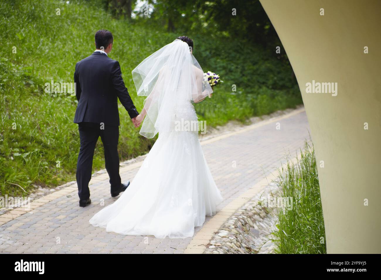 The bride and groom are walking along the path Stock Photo - Alamy