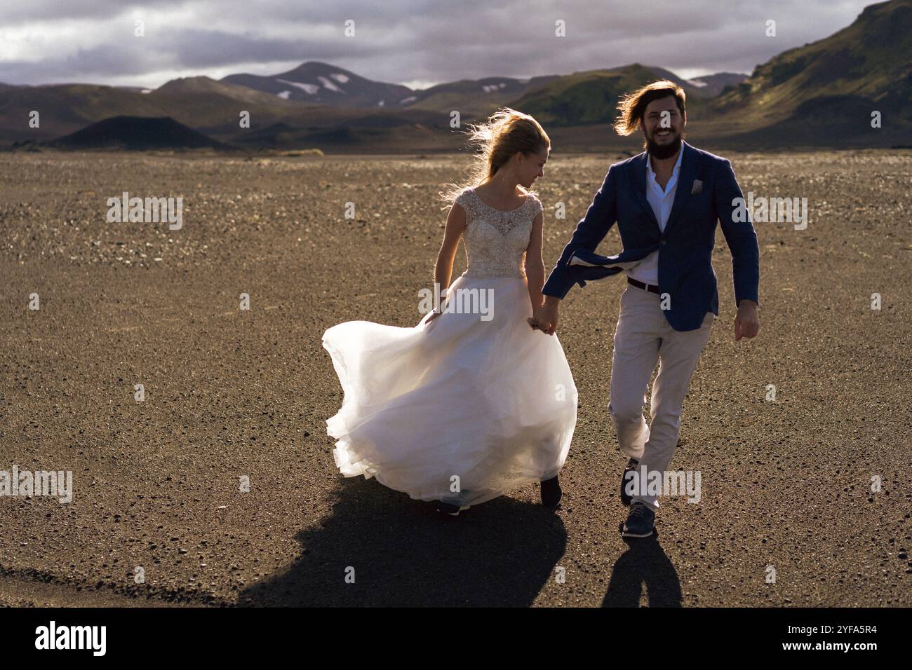 Couple in wedding suits in Iceland against the mountains Stock Photo