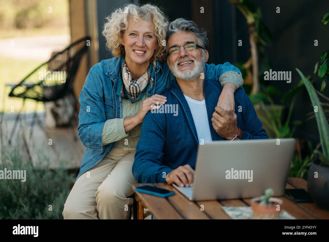 Middle-age couple smiling confident using laptop in the garden. Stock Photo