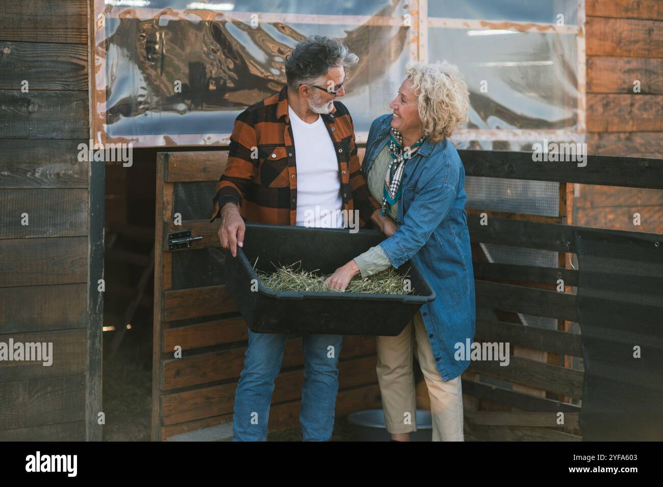 A middle-aged couple exchanging glances while preparing the food Stock Photo
