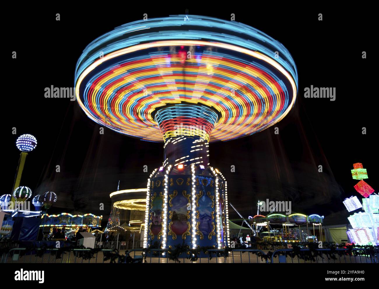 NICOSIA, CYPRUS, DECEMBER 12: Merry go round, Carousel spinning fast creating wonderful light trails at an amusement park during Christmas holidays on Stock Photo