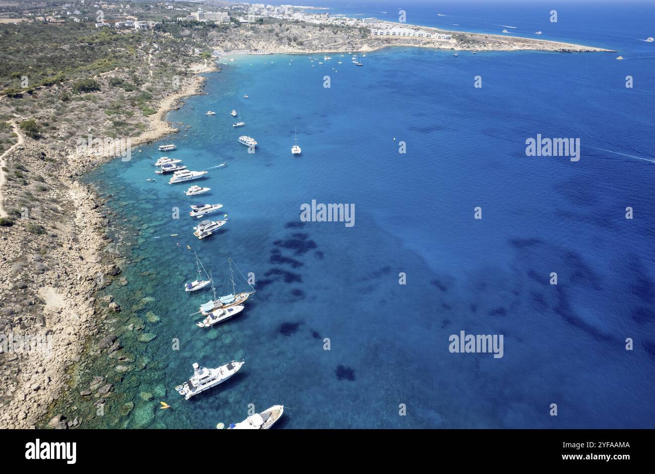 Drone aerial seascape with luxury yachts moored on the coast and unrecognised people swimming and relaxing. Summer vacations in the sea. Ayia Napa Cyp Stock Photo
