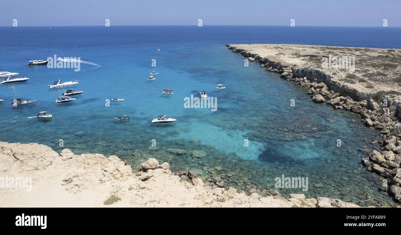 Drone aerial seascape with luxury yachts moored on the coast and unrecognised people swimming and relaxing. Summer vacations in the sea. Ayia Napa Cyp Stock Photo