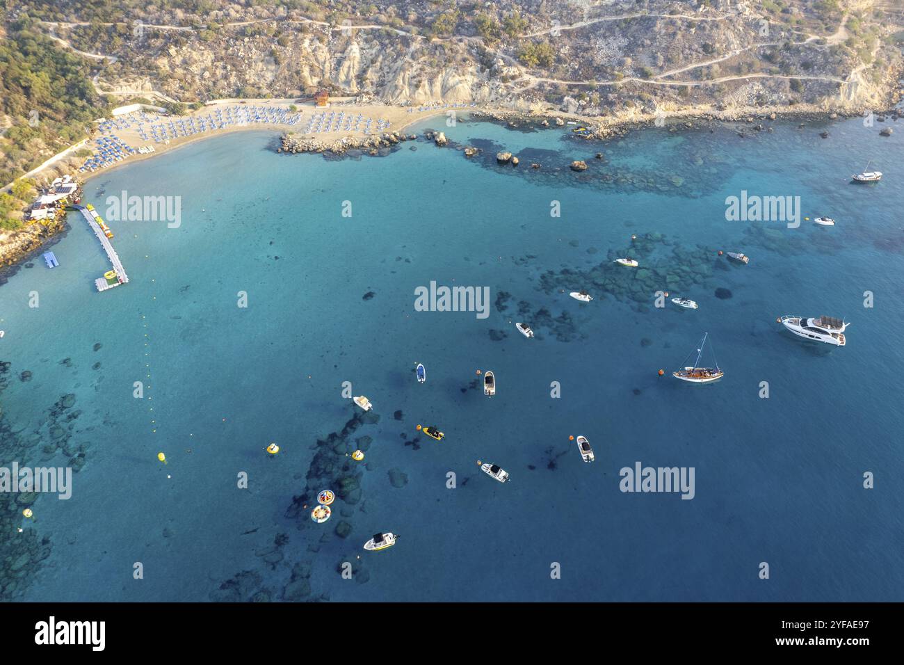 Drone aerial seascape with luxury yachts moored on the coast and unrecognised people swimming and relaxing. Summer vacations in the sea. Konnos bay Ay Stock Photo