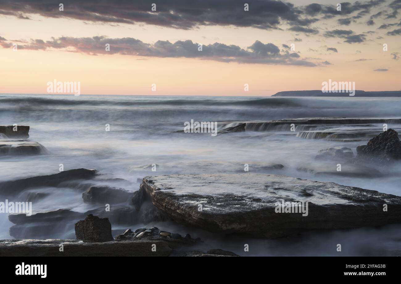 Dramatic beautiful sunset on a rocky coast. Akrotiri, Limassol, Cyprus. Long exposure photography Stock Photo