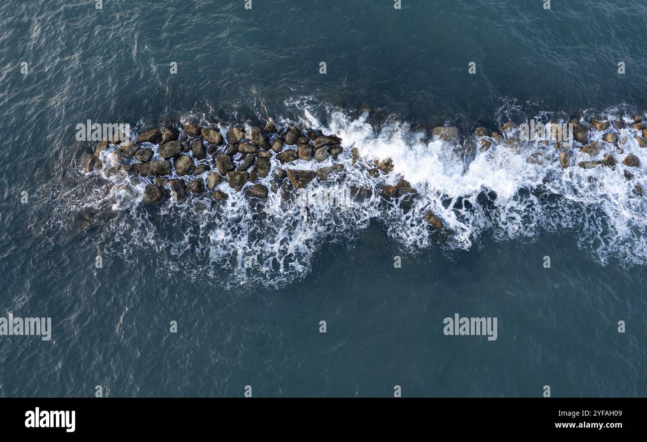 Aerial view from a flying drone of blue sea water and break water. Sea ...