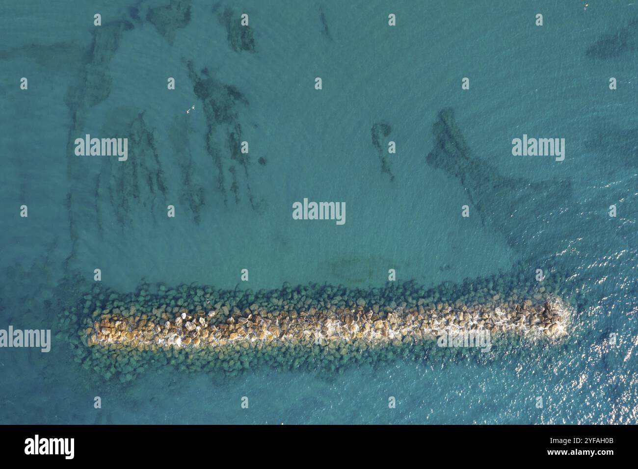 Aerial view from a flying drone of blue sea water and breakwater. Sea ...