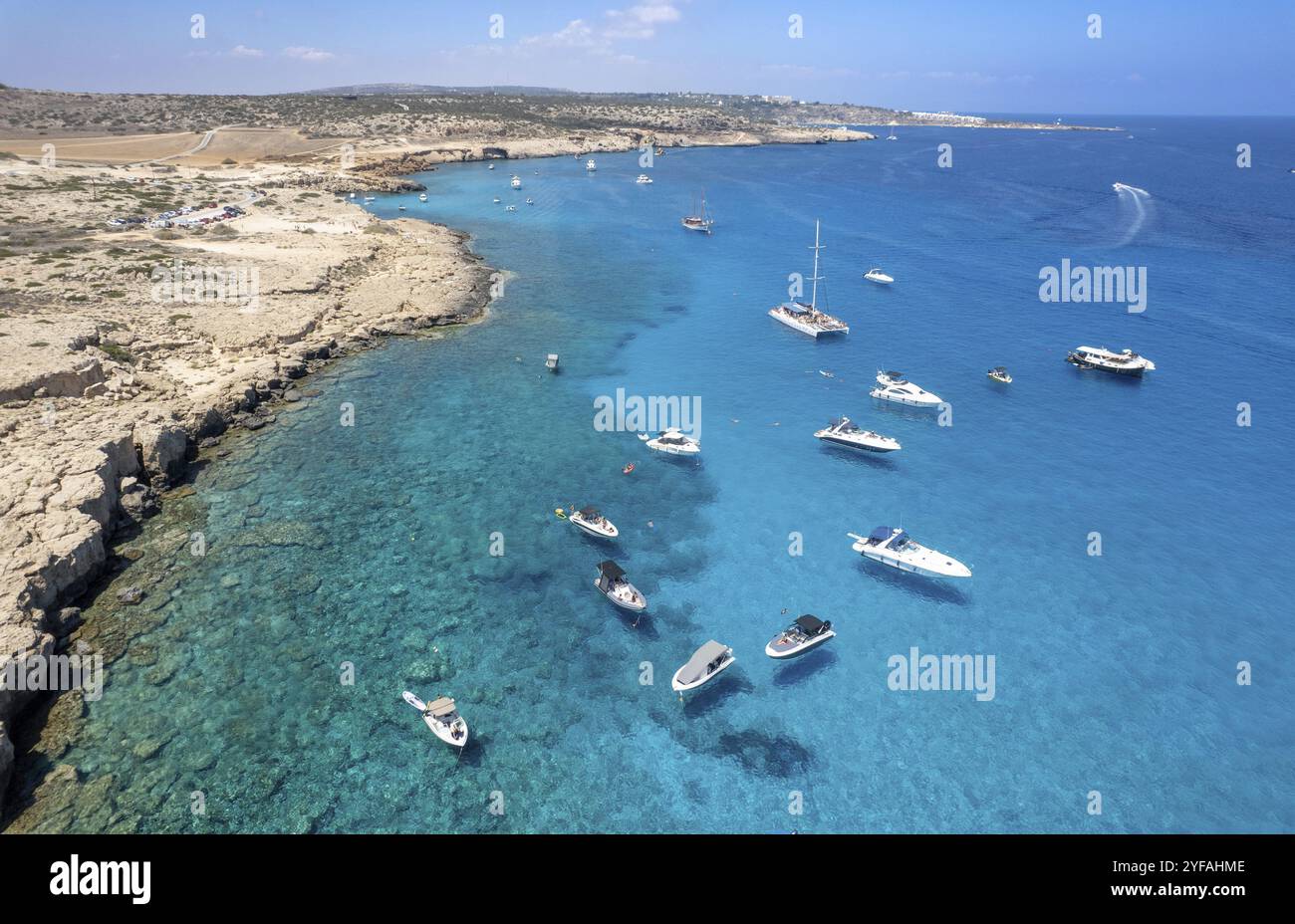 Drone aerial seascape with luxury yachts moored on the coast and unrecognised people swimming and relaxing. Summer vacations in the sea. Ayia Napa Cyp Stock Photo