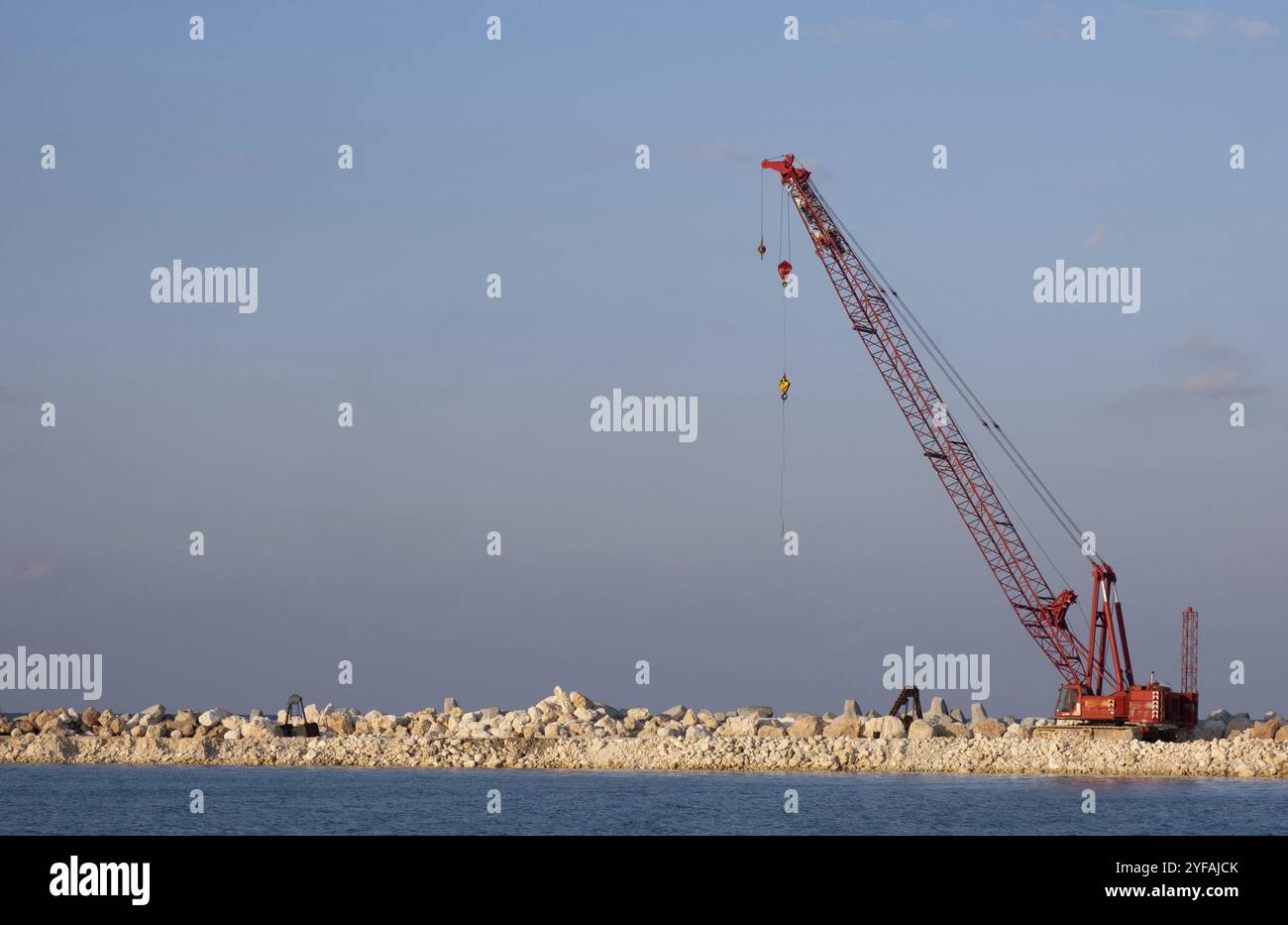 Crane machine building a water barier at a marina. Protaras Cyprus ...