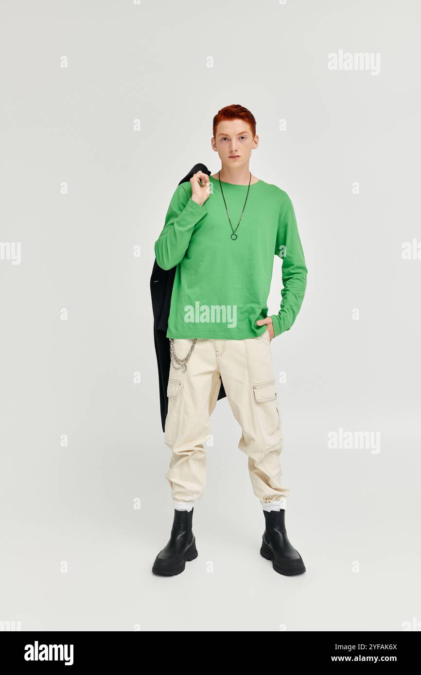 A stylish young man in green long sleeve poses confidently against a ...