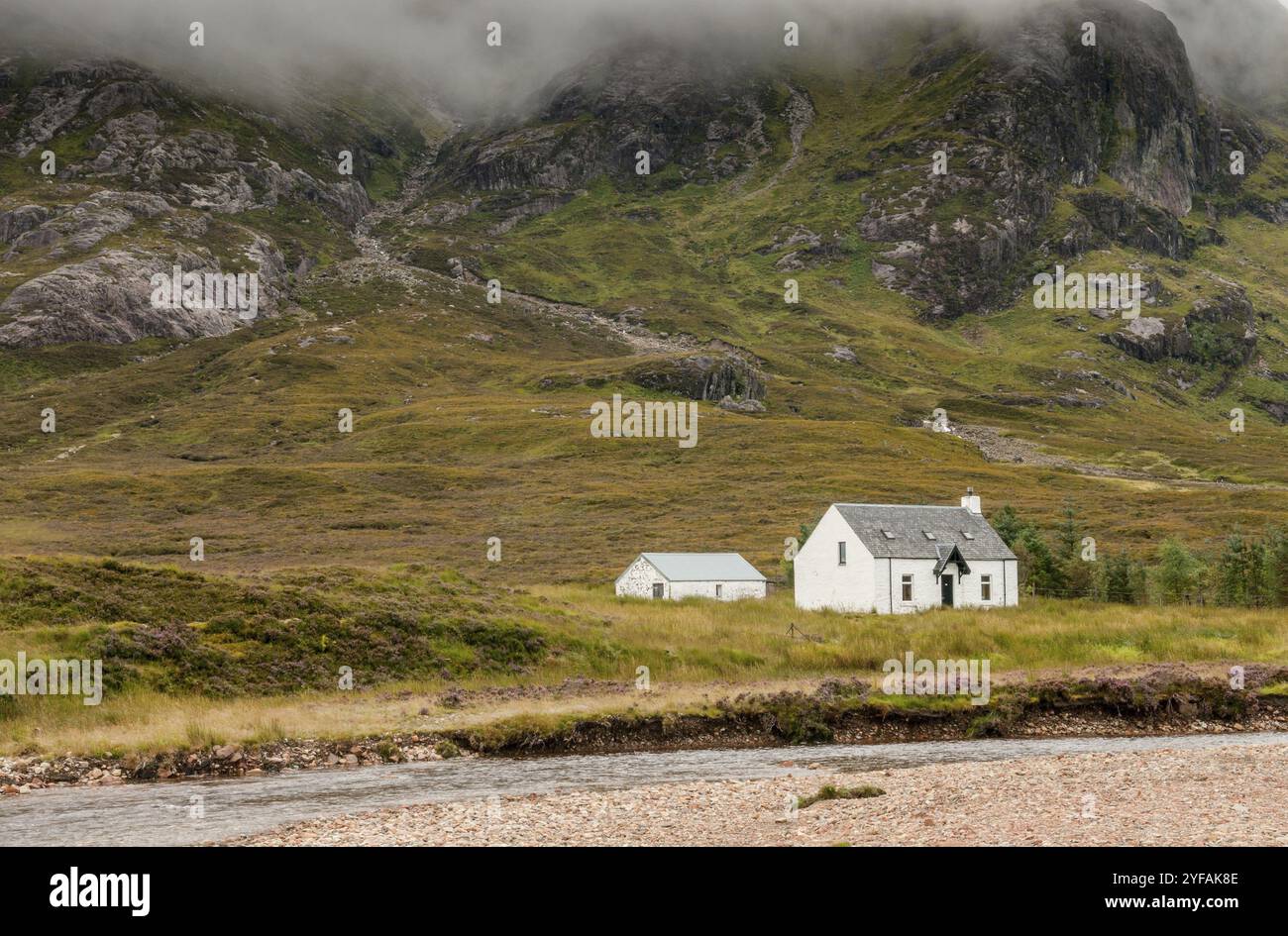 Typical Scottish white farmhouse used as a guesthouse or hostel under the mountains in Glencoe area in the Highlands of Scotland UK Stock Photo