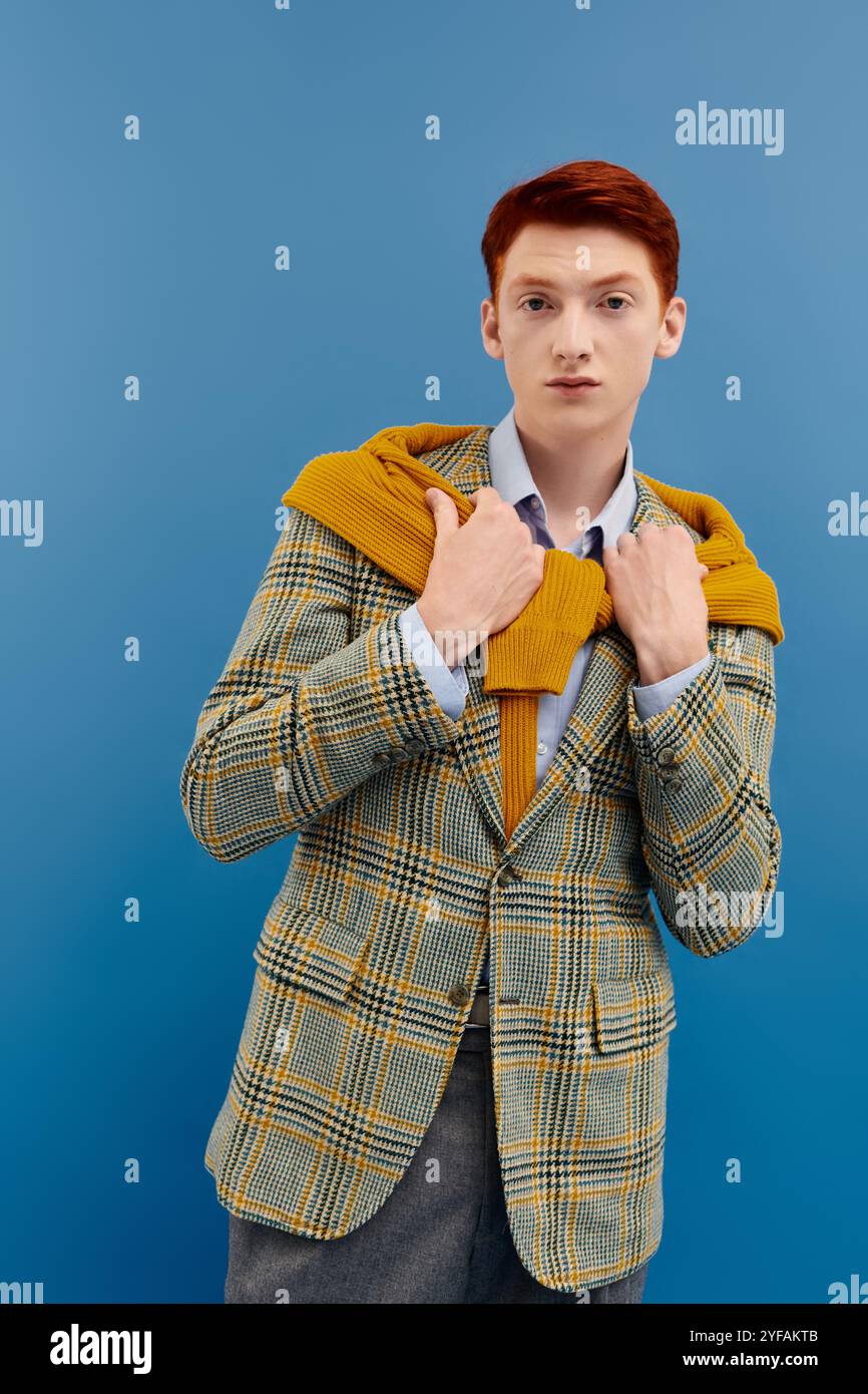 A young man showcases his fashion with layered winter attire against a ...