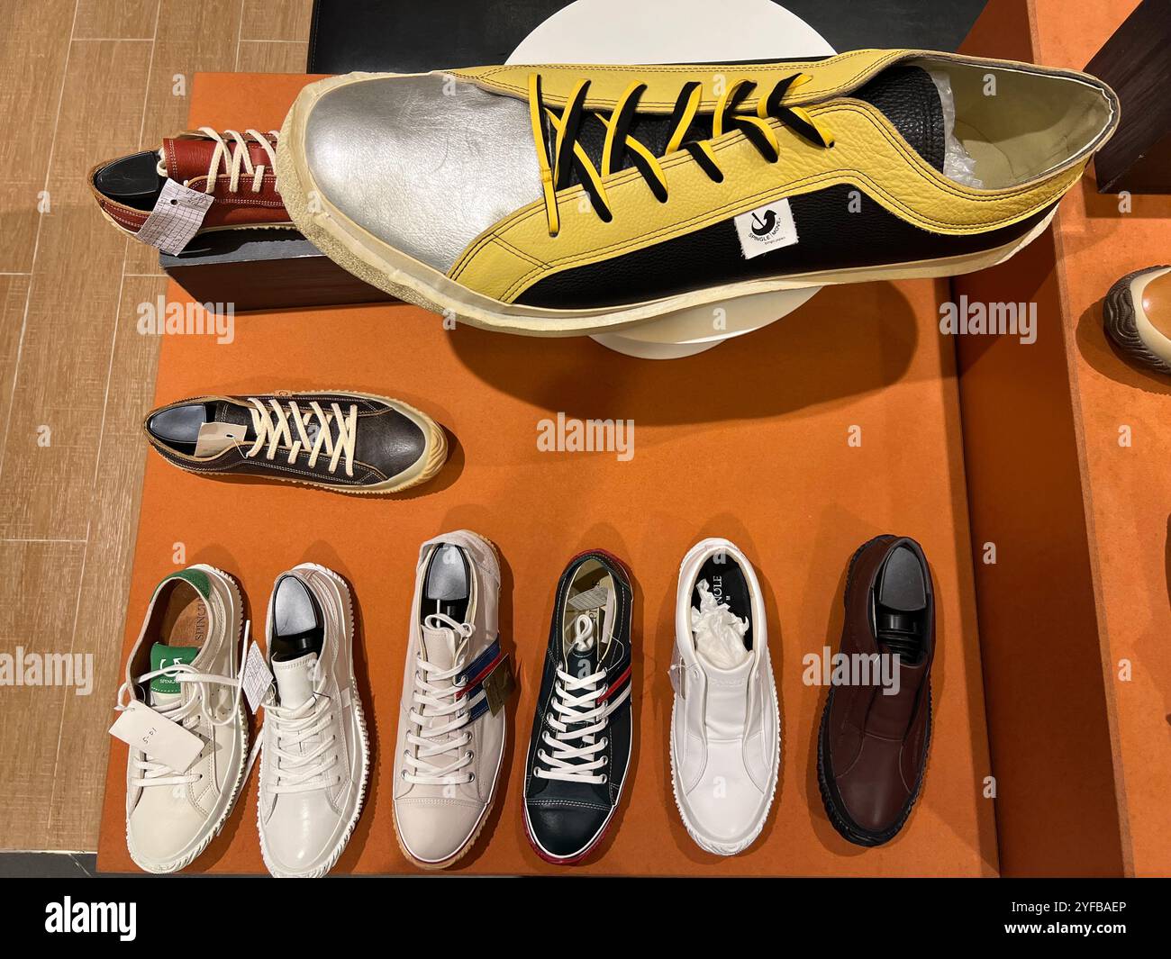 A huge Spingle handmade mens sneakers on display departmental store. The scale of it can be compare with their normal sizes products. Made in Japan. - Smartphone Captured Stock Image