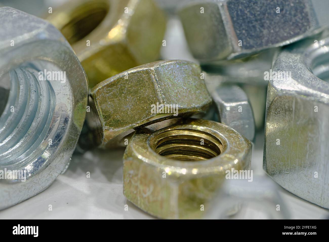 Assorted galvanized hex nuts of various sizes, close up shot. Stock Photo