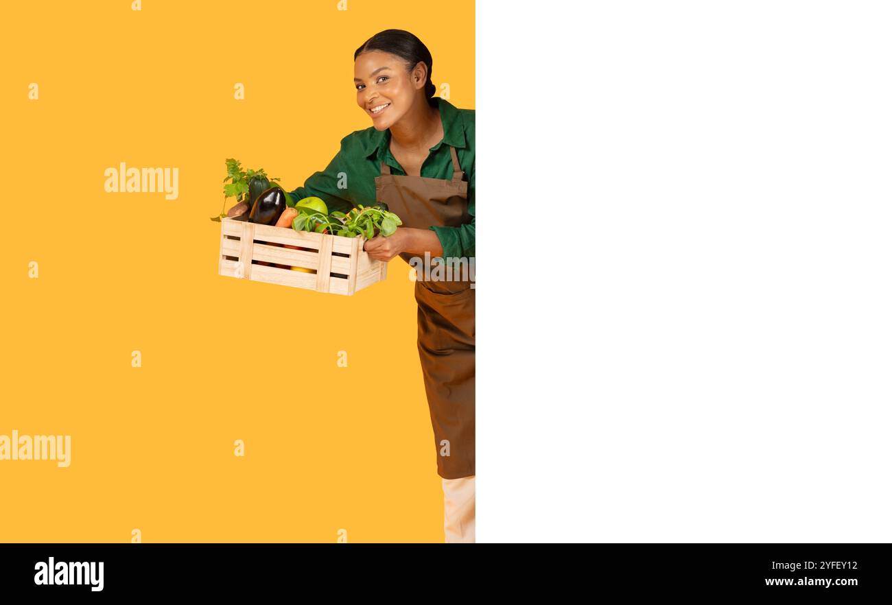 Woman smiles with a wooden crate of fresh veggies in bright light Stock ...