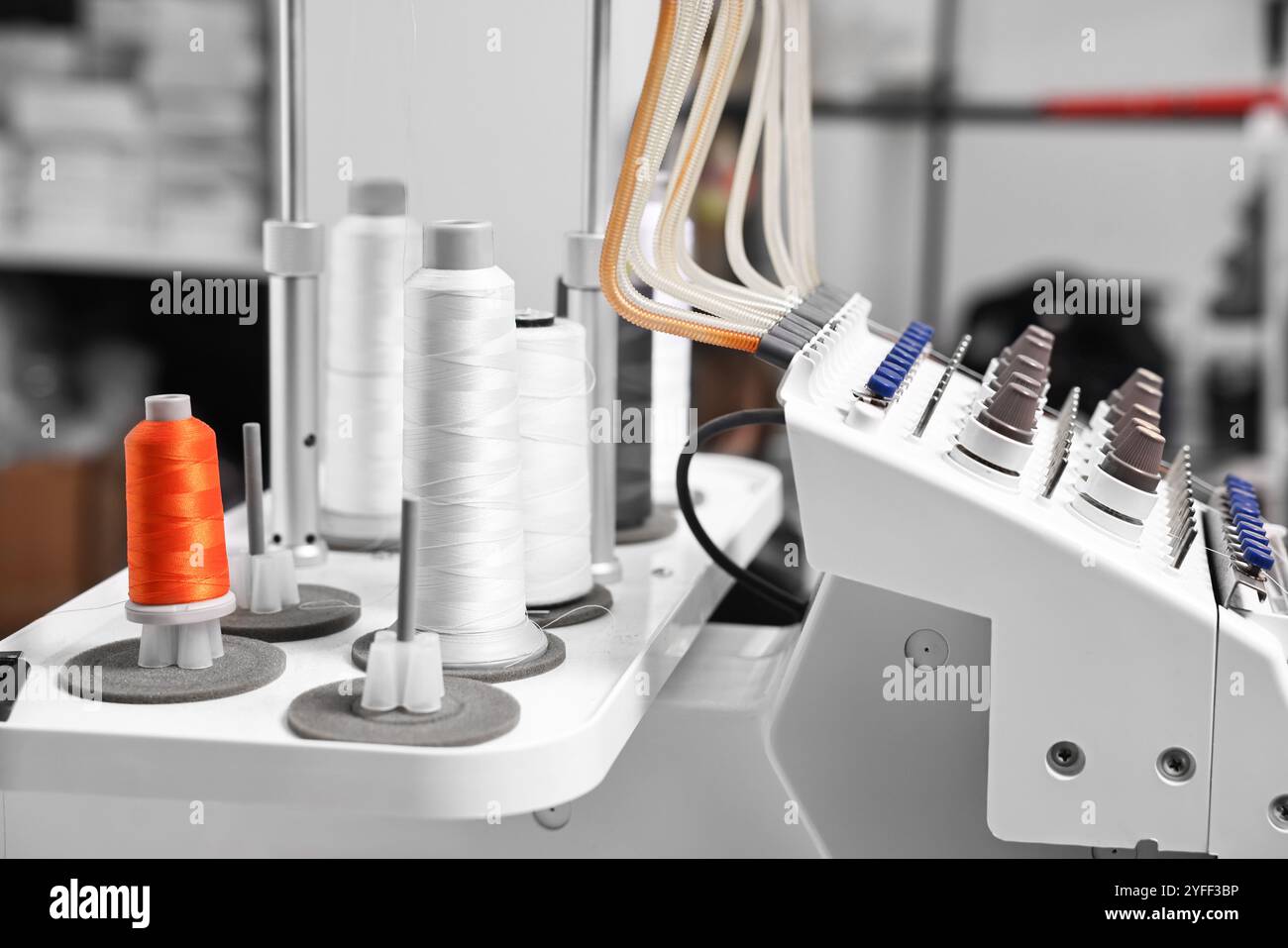 Sewing machine with spools of thread in professional workshop, closeup ...