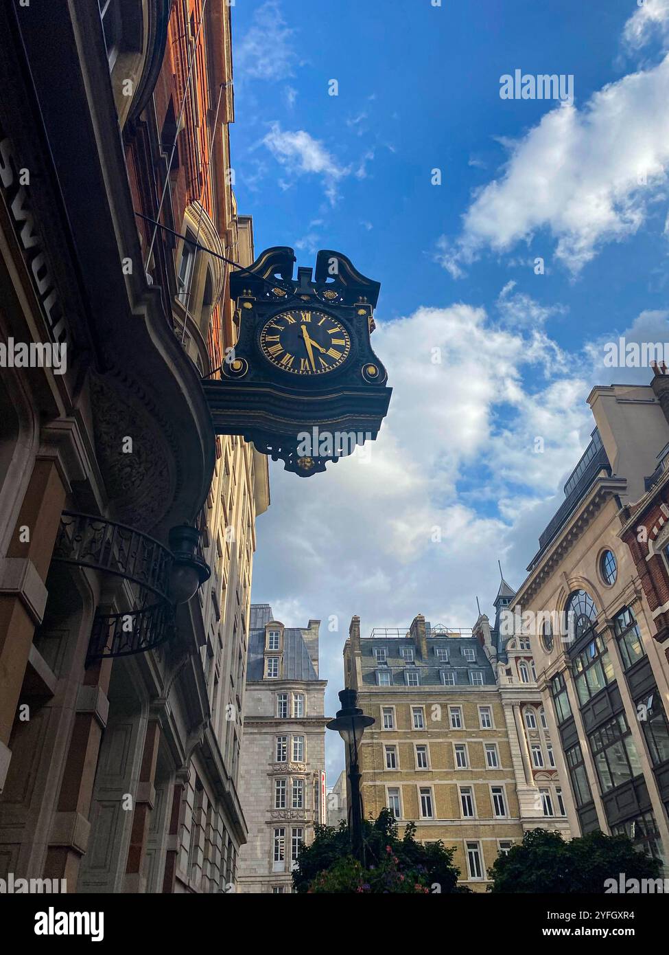 Vintage Street Clock on a Historic London Building with Blue Sky Background - Smartphone Captured Stock Image