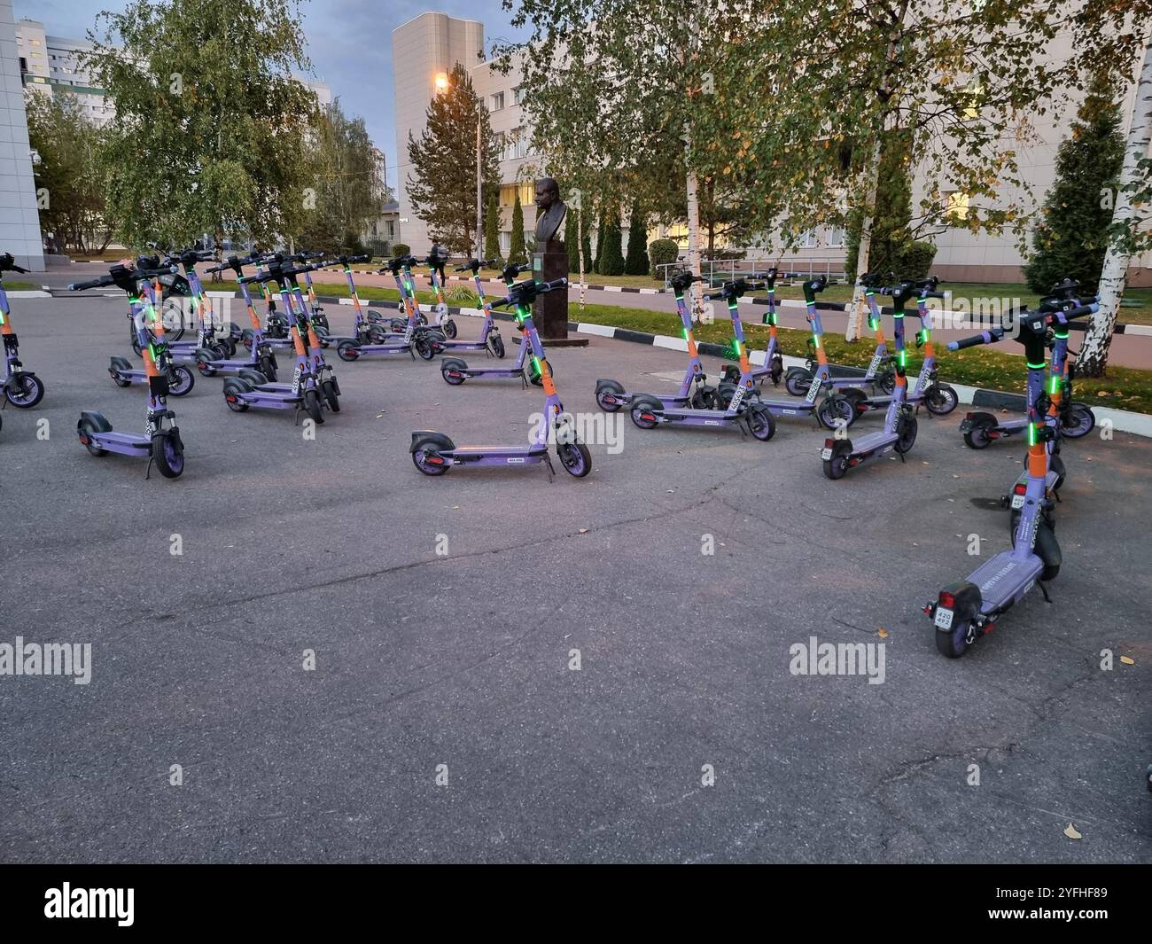 Large number of electric rental scooters left behind on a square; lights are flashing; blue scooters - Smartphone Captured Stock Image
