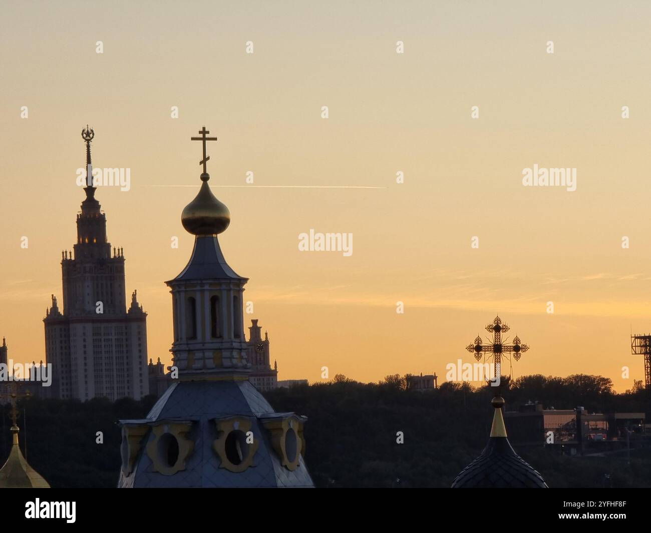 Evening view of Russian Orthodox church towers with Orthodox crosses against a coloured, orange red sky; Moscow skyline - Smartphone Captured Stock Image