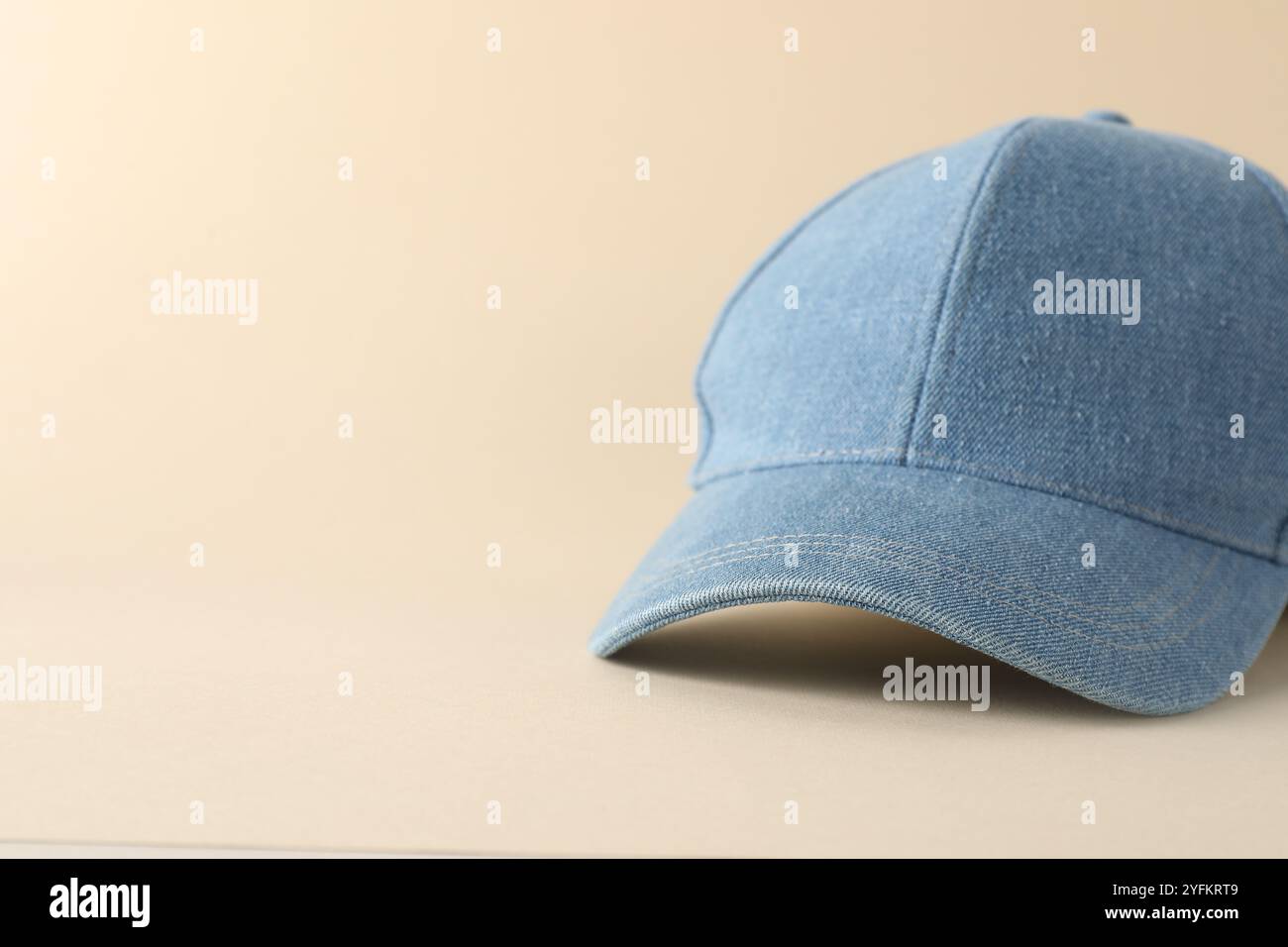 Stylish denim baseball cap on beige background, closeup. Mockup for design Stock Photo