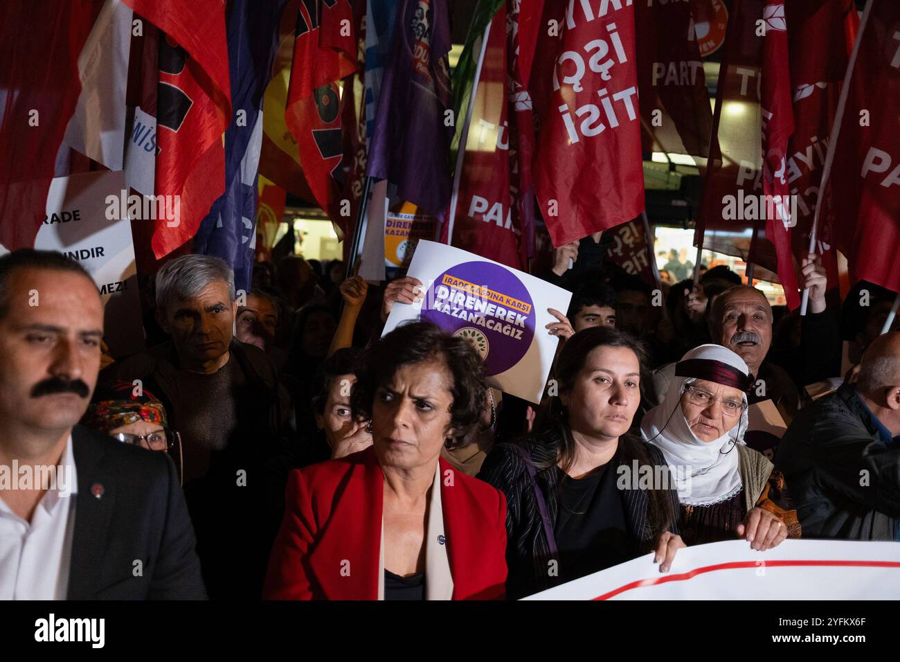 A protester holds a placard that says 'We will win by resisting against the usurpation of will' during the rally. The Official Gazette of the Republic of Turkey announced the dismissal of Mardin Metropolitan Mayor Ahmet Türk, Batman Mayor Gülistan Sönük and Halfeti Mayor Mehmet Karay?lan. The appointment of trustees to DEM (Peoples' Democratic Party) municipalities was met with protests across the country. Kurdish people and opposition political groups supporting them say it is a coup against the will of the people. In Izmir, Kurdish groups and opposition parties organized a joint protest and Stock Photo