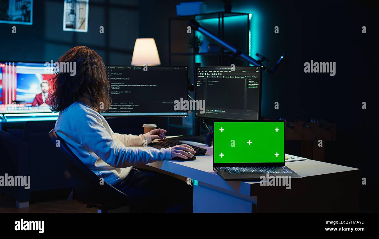 Admin using green screen laptop to implement security measures, protecting company systems and data. IT worker testing and debugging code for software applications on chroma key notebook, camera B Stock Photo