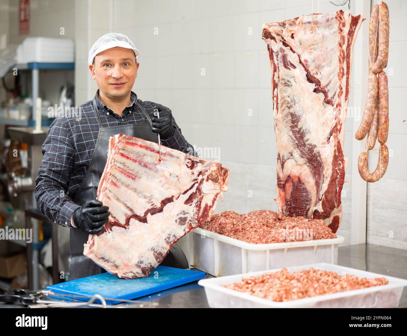 Adult male butcher holding beef ribs Stock Photo - Alamy